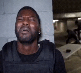 black man looking at his undercover agent friend get jumped in despair, realizing he's next if found out.