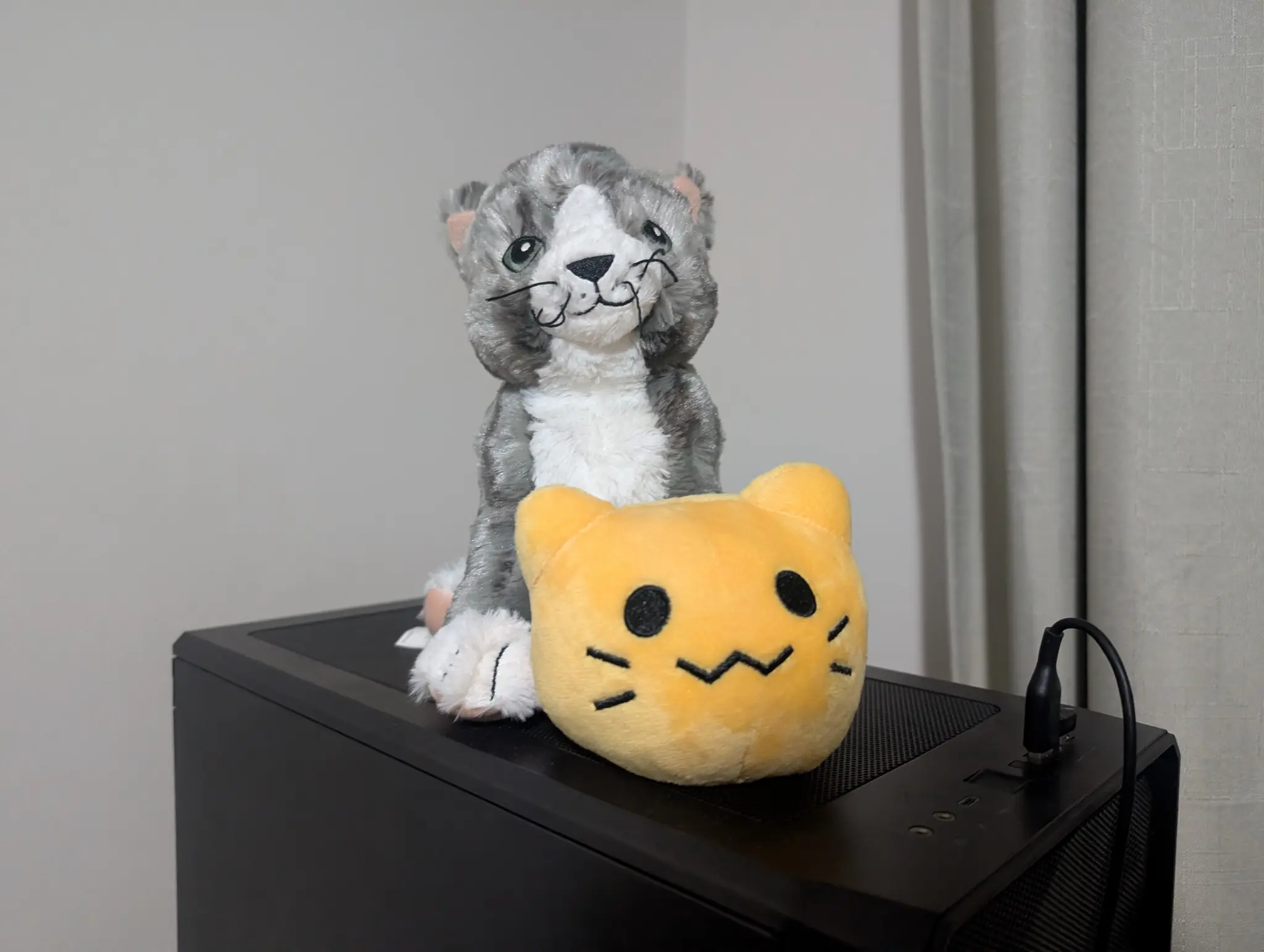 Blobcat plushie in front of Ikea Lileplutt plushie on top of my PC